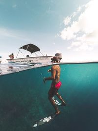 Woman in swimming pool by sea against sky