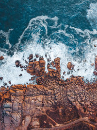 Majestic rocky show line with waves crashing onto it.