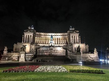 Illuminated building against sky at night