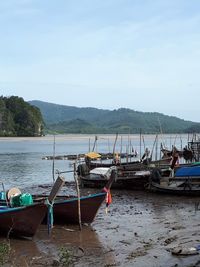 Boats moored on beach against sky