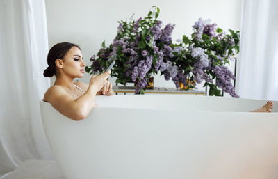 Portrait of young woman washing hands in bathroom