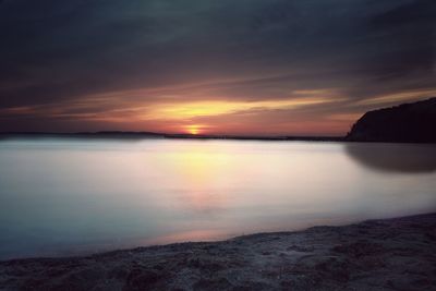 Scenic view of sea against dramatic sky during sunset