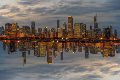 Reflection of buildings in river against sky