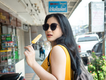 Portrait of young woman holding smart phone outdoors