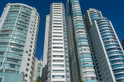 Low angle view of modern buildings against blue sky