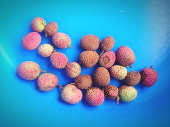 High angle view of strawberries on table against blue background