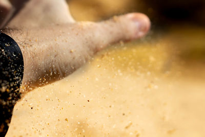Close-up of person hand with sand