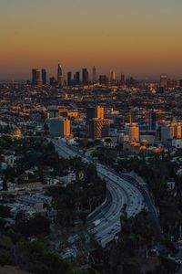 High angle view of illuminated cityscape against sky during sunset