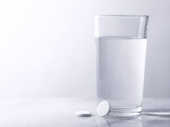 Pills and glass of water isolated on white background