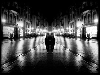 People walking in illuminated city at night