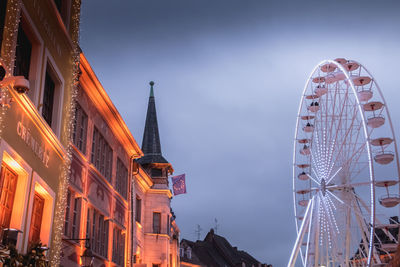 Low angle view of ferris wheel in city against sky