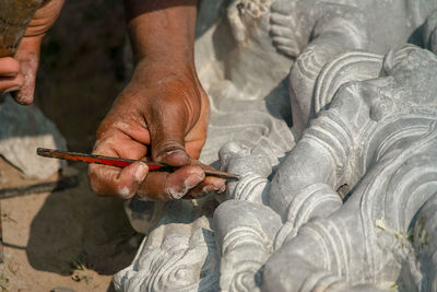 Cropped hands of man working on sculpture