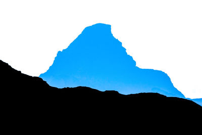 Low angle view of silhouette mountain against clear sky