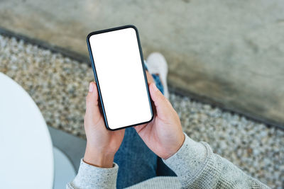 Low section of woman using mobile phone