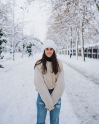 Portrait of young woman standing in snow