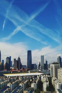 Modern buildings in city against blue sky