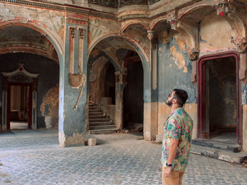 Full length rear view of a man standing in building