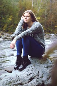 Young woman sitting on rock