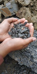 High angle view of hands holding rock
