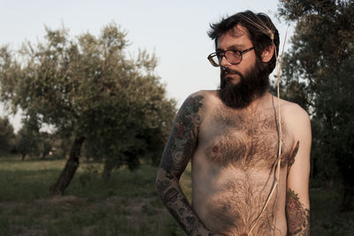 Shirtless man standing on grassy field