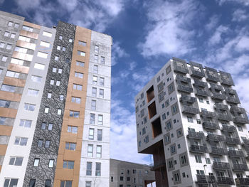 Low angle view of buildings against cloudy sky