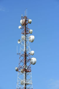 Low angle view of communications tower against blue sky