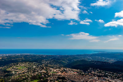 Aerial view of city by sea against sky