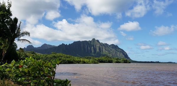 Scenic view of sea and mountains against sky