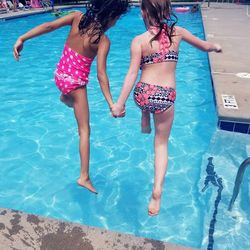 Girls jumping in swimming pool