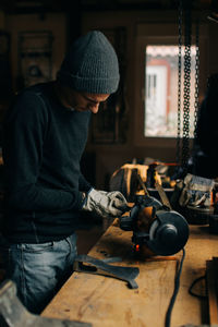 Crop craftsman checking axe in workshop