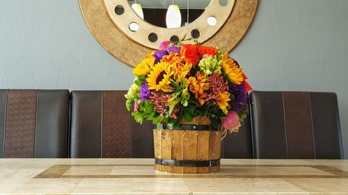 Flower vase on table against wall