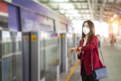 Woman standing by train at railroad station