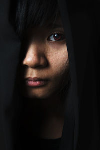 Close-up portrait of woman in darkroom