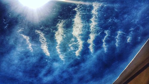 Low angle view of bright sun in sky