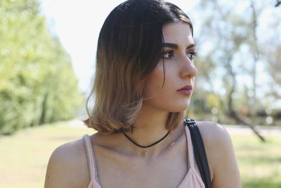 Close-up of thoughtful young woman standing at park