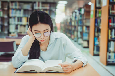 Young man sitting on book