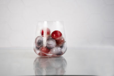 Frozen berries in ice cubes covered with hoarfrost in glass. homemade food. top view.