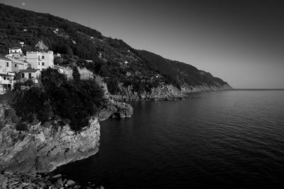 Scenic view of sea by buildings against clear sky