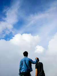 Rear view of men standing against sky