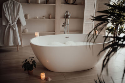 Luxury interior of big bathroom at modern african style with oval bathtub in natural lighting