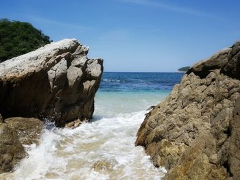 Scenic view of rocks in sea against sky