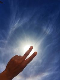 Low angle view of hand against sky