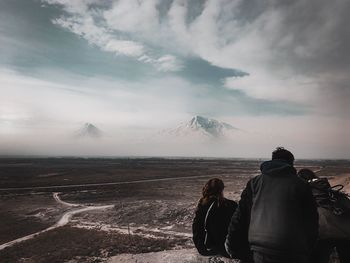 Rear view of woman looking at mountain against sky