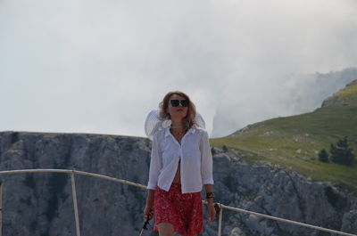 Woman standing on mountain against sky