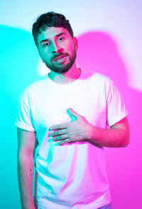Portrait of young man standing against blue background