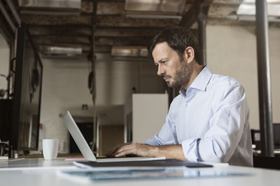 Businessman using laptop in office