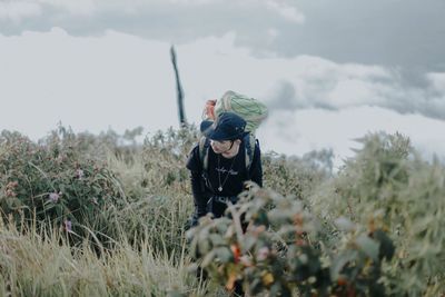 Woman standing on field against sky