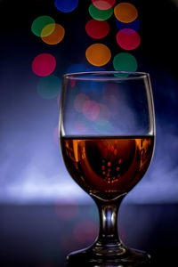 Close-up of wineglass on table against black background