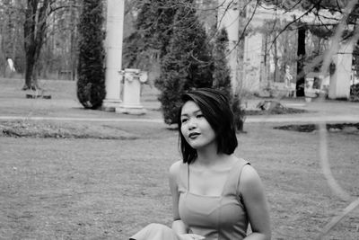 Portrait of young woman standing on grass