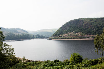 Scenic view of lake and mountains against clear sky